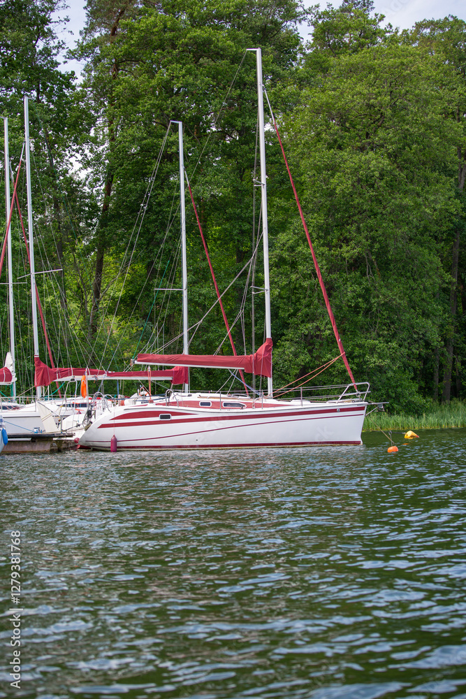 Yachts moored in small marina on wooded coast on Masurian Lakes, Masuria, Masurian Lake Land, Poland