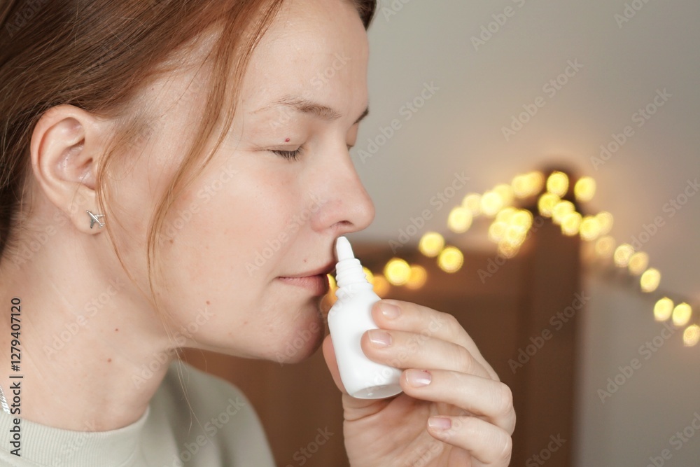 Young woman using nasal spray while sick Young woman using nasal spray while sick