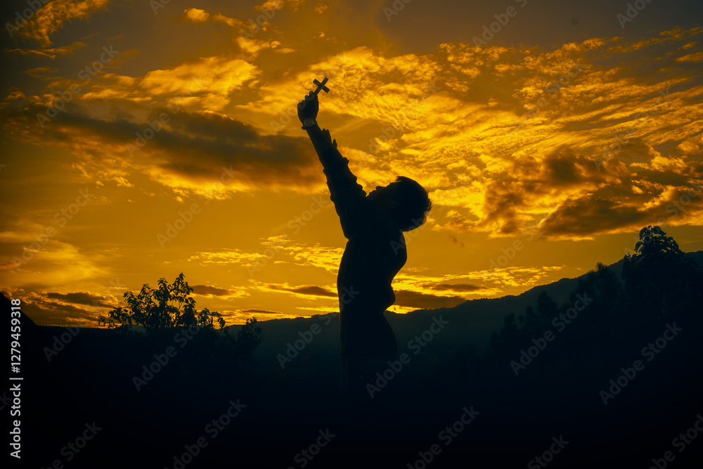 man standing praying and holding christian cross for worshipping God at sunset background. christian silhouette concept. man standing praying and holding christian cross for worshipping God at sunset background. christian silhouette concept.