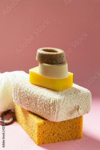 Obraz na płótnie Set of bath accessories, sponges of different sizes and shapes and handmade soap on a pink background. w salonie