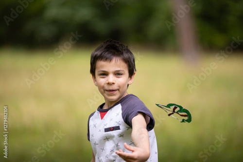 Obraz na płótnie Little adorable boy paying with handmade drone in park w salonie