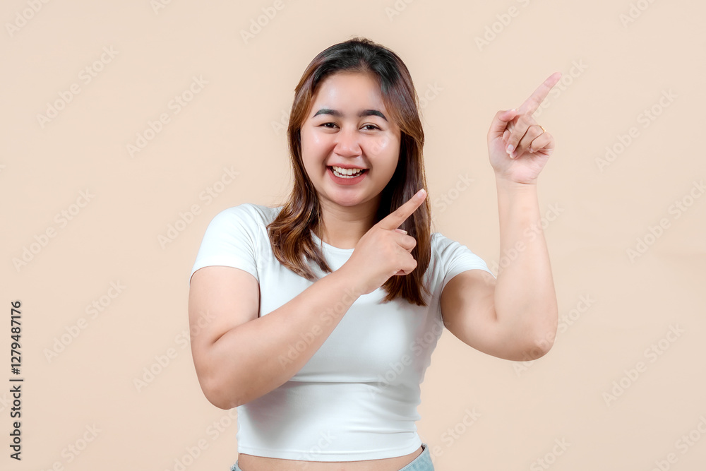 A cheerful young woman smiling and playfully pointing in different directions, set against a soft beige background, exuding enthusiasm and positivity. A cheerful young woman smiling and playfully pointing in different directions, set against a soft beige background, exuding enthusiasm and positivity.