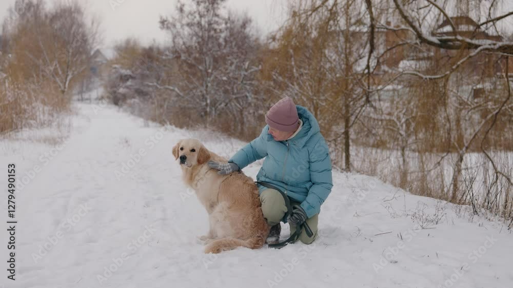 Active senior woman enjoying a winter walk with her Golden Retriever, promoting a healthy lifestyle and outdoor activity.