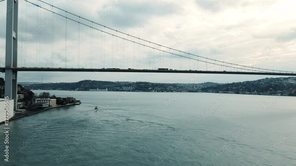 Transport traffic on Turkish Bosphorus bridge in sunset from aerial view, famous Bosphorus bridge spanning the Bosphorus strait and connecting Europe and Asia