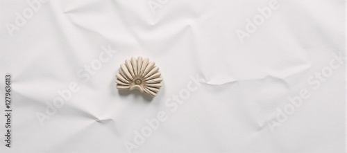 Blank paper with a textured appearance of crumples and creases serves as the backdrop for an image