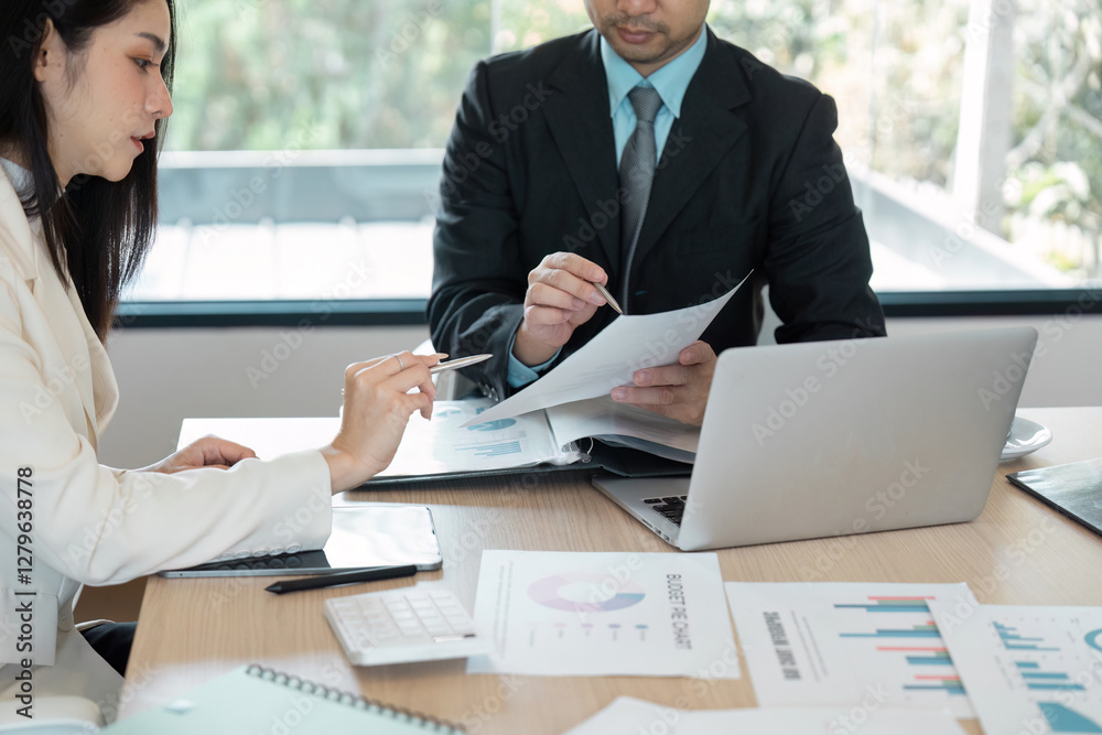 Financial experts reviewing documents and strategizing in a contemporary office environment. Financial experts reviewing documents and strategizing in a contemporary office environment.