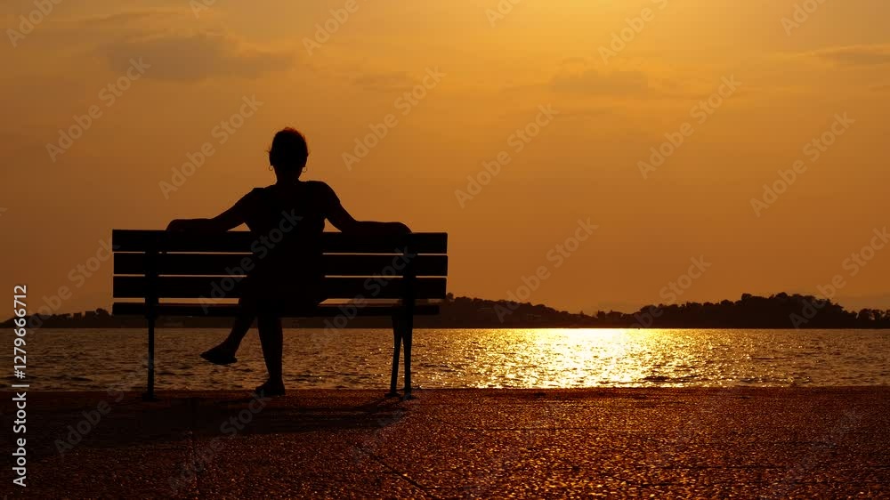 Woman watching sea during evening. A happy woman silhouette watching the calm water of evening sea in summer. Woman watching sea during evening. A happy woman silhouette watching the calm water of evening sea in summer.