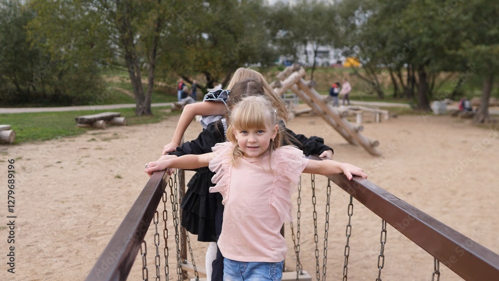 A joyful child plays excitedly on a colorful bridge at a park with cheerful friends, creating beautiful memories A joyful child plays excitedly on a colorful bridge at a park with cheerful friends, creating beautiful memories
