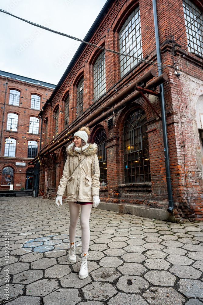 Woman posing on old red brick workers building in a neighborhood of Lodz Woman posing on old red brick workers building in a neighborhood of Lodz