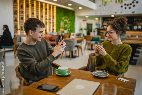 boyfriend use mobile phone to take a photo of his girlfriend at cafe photo