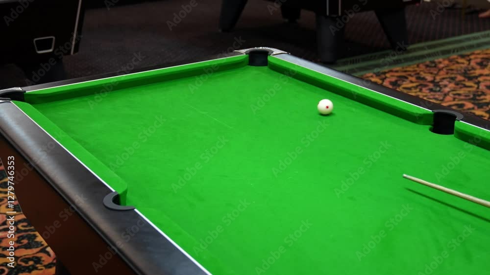 Wining the game by pocketing the black ball in blackball Pool game on a green cloth pool table, hit by the cue pocketing