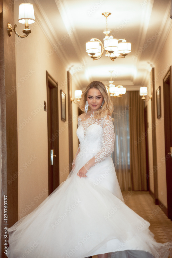 Beautiful blonde bride in a long white dress posing in the hotel corridor Beautiful blonde bride in a long white dress posing in the hotel corridor