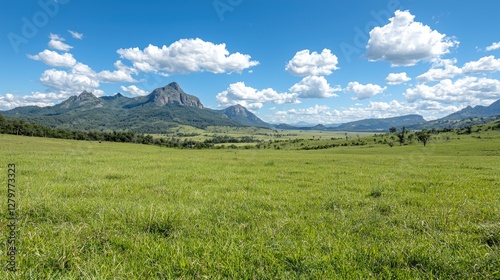 Lush Green Valley with Mountains Under Sunny Sky. Possible use Stock photo for nature tourism or travel brochures