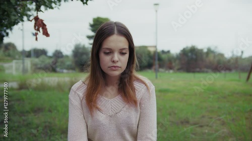 Sad And Lonely Girl Sitting In Park Bench Outdoors