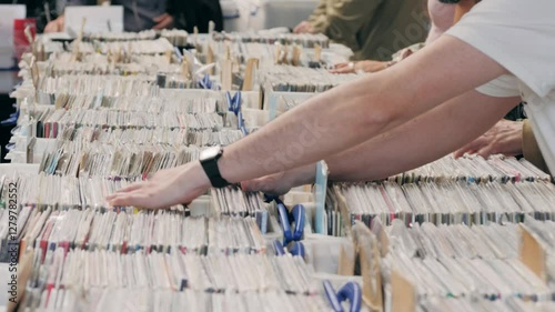 People browsing vinyl records in a music store, surrounded by retro albums in physical format photo