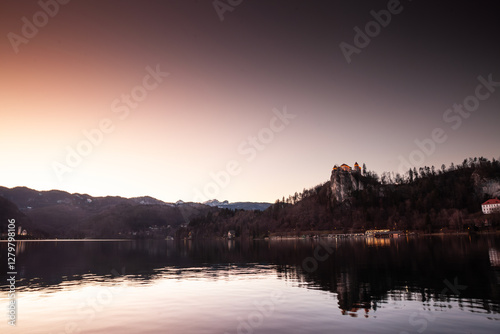 Panorama of the Bled lake, Blejsko Jezero, with its castle, Blejski Hrad, during a winter dusk sunset with the mountains of Julian alps. Bled Castle is a major monument of Slovenia. photo