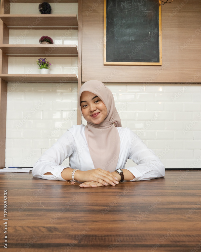 Confident Young Woman in Hijab Sitting at Café Table Confident Young Woman in Hijab Sitting at Café Table