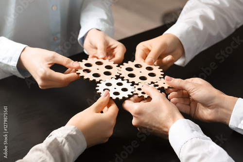 Group of business people holding wooden gears at table