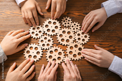 Hands holding wooden gears ...