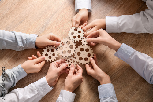 Hands holding wooden gears ...