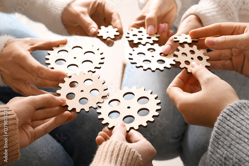 Group of people holding wooden gears