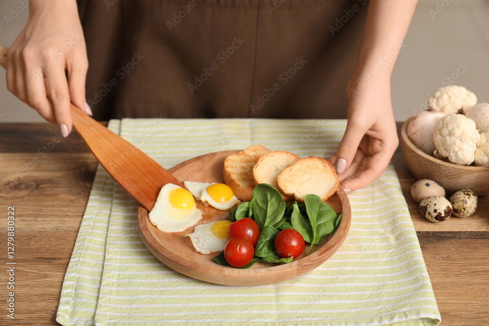 Woman preparing tasty dinner with fried quail eggs, fresh vegetables and toasts in kitchen, closeup Woman preparing tasty dinner with fried quail eggs, fresh vegetables and toasts in kitchen, closeup