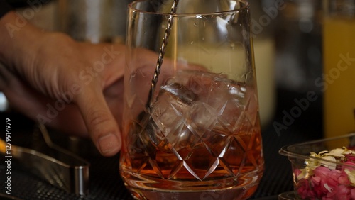 Foto Cropped closeup hand bartender stirring mixed ingredients alcohol liquor syrup into mixing glass with cube ice prepared Old fashioned cocktail tasting showcasing nightlife mixology at bar
