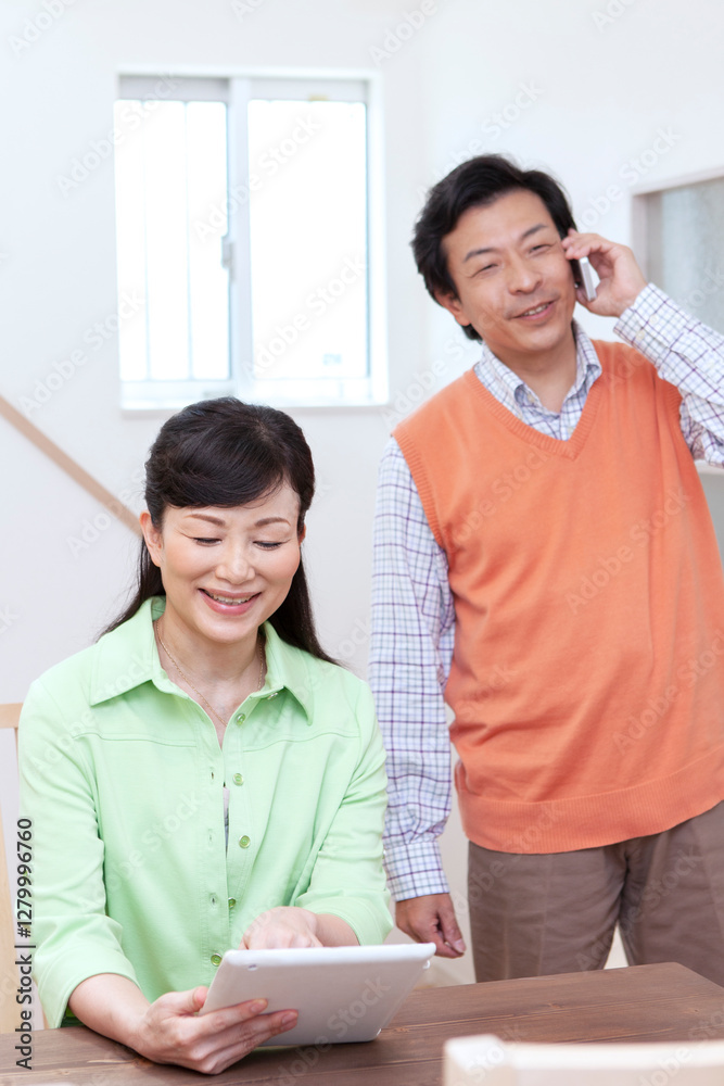 タブレットを見て話す夫婦