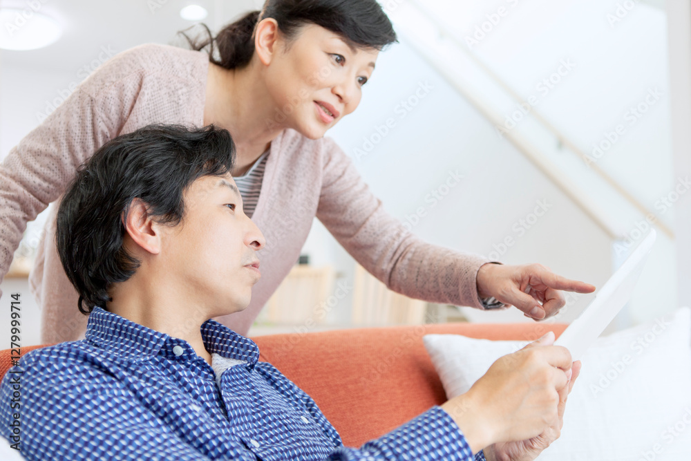 Fototapeta premium タブレットを見て話す夫婦