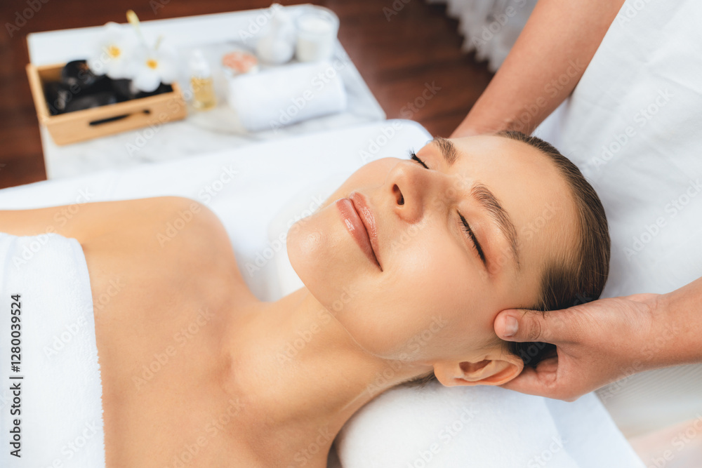 Caucasian woman enjoying relaxing anti-stress head massage and pampering facial beauty skin recreation leisure in dayspa modern light ambient at luxury resort or hotel spa salon. Quiescent Caucasian woman enjoying relaxing anti-stress head massage and pampering facial beauty skin recreation leisure in dayspa modern light ambient at luxury resort or hotel spa salon. Quiescent