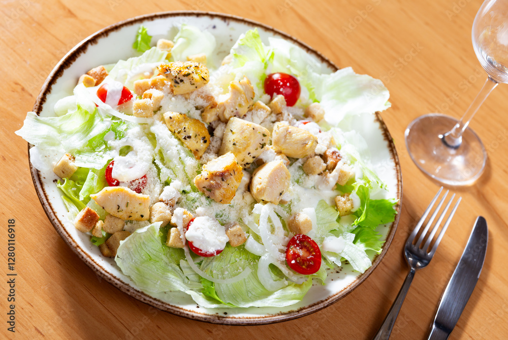 Delicious fresh caesar salad with parmesan and sliced chicken served on plate Delicious fresh caesar salad with parmesan and sliced chicken served on plate