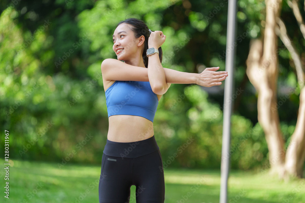 Happy sportswoman warming up outdoors in a green park, wearing a smartwatch and stylish sportswear, embracing an active lifestyle and enjoying the essence of wellness Happy sportswoman warming up outdoors in a green park, wearing a smartwatch and stylish sportswear, embracing an active lifestyle and enjoying the essence of wellness