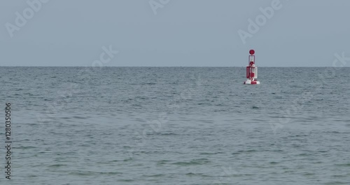 Red and White Navigational buoy in sea