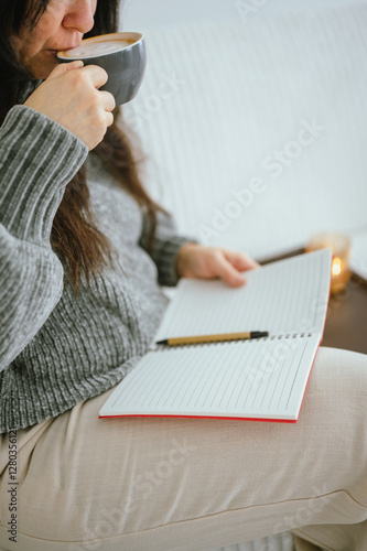 Woman sipping coffee while journaling during morning routine