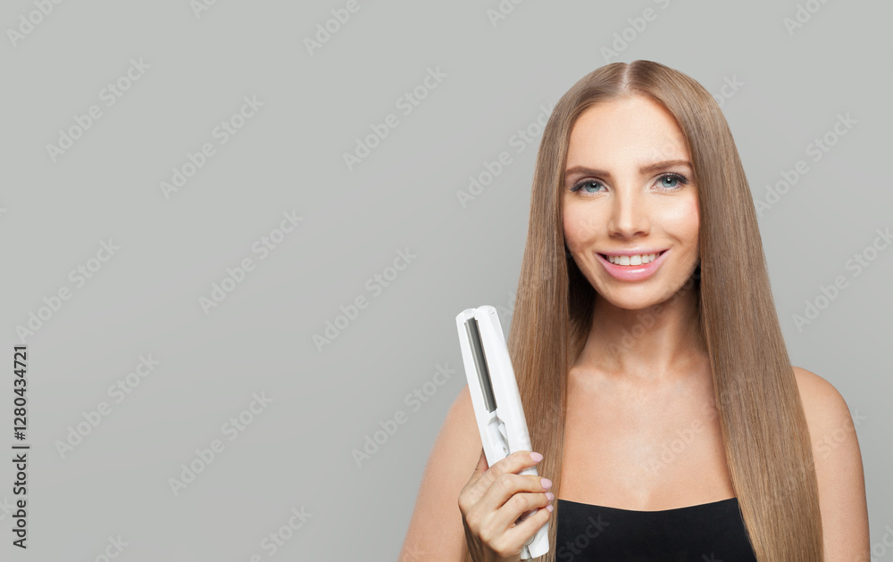 Lovely brunette woman holding straight hair iron and straightening her long smooth shiny hair on white background. Haircare, hairstyle, hairdressing and hair styling concept Lovely brunette woman holding straight hair iron and straightening her long smooth shiny hair on white background. Haircare, hairstyle, hairdressing and hair styling concept