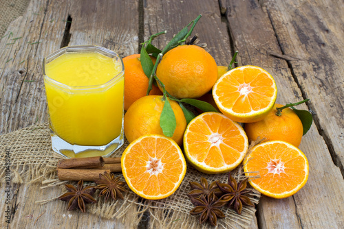 orange juice and some fresh fruits on wooden background