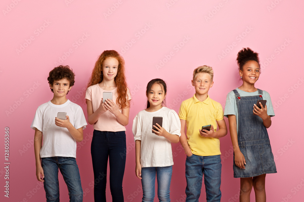 Portrait of multiracial children using cellphones to study online over pink background Portrait of multiracial children using cellphones to study online over pink background