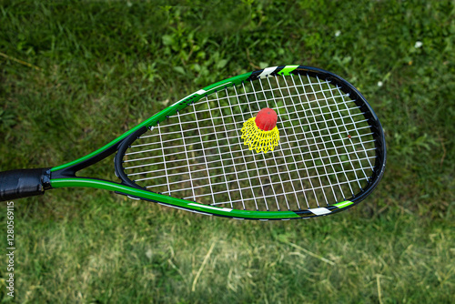 Badminton racket with shuttlecock on a background of green grass