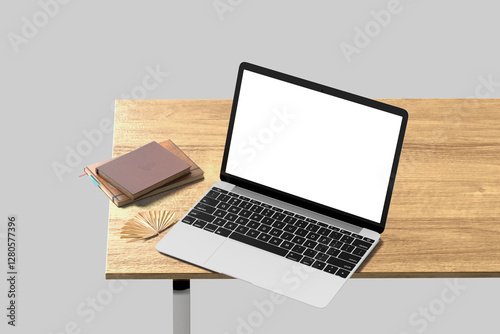 Blank laptop screen on wood table with books