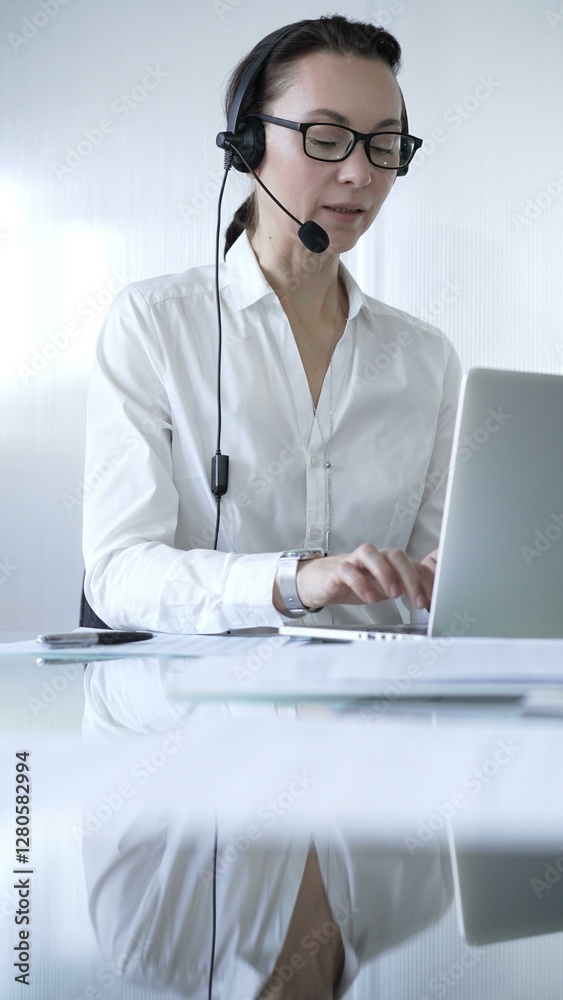 Female secretary wearing headset and working on laptop, providing customer support or online service. Business people concept Female secretary wearing headset and working on laptop, providing customer support or online service. Business people concept