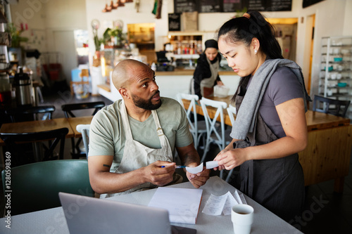 Male owner questioning female colleague over financial bills at cafe photo