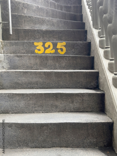 Concrete stairs with the number 325 painted in yellow.