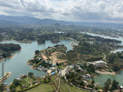 Aerial view of a scenic landscape with winding rivers and lush greenery under a cloudy sky.