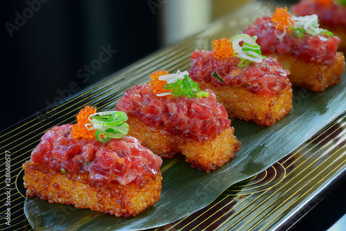 beautifully plated dish of crispy rice topped with spicy tuna tartare.