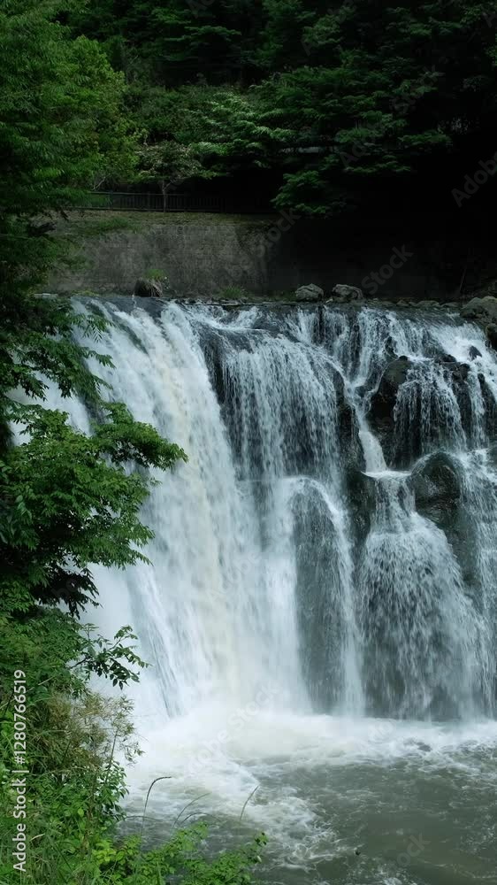 A waterfall cascades in a tropical rainforest with rock. A waterfall cascades in a tropical rainforest with rock.