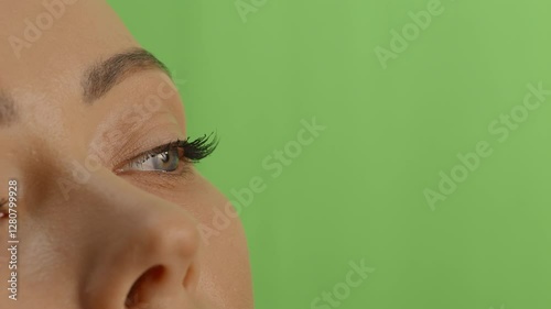 Close up view on woman's eye, unrecognizable woman on chromakey green background. Person tryes on contact lens, concept of living with sight disorders. High quality 4k footage