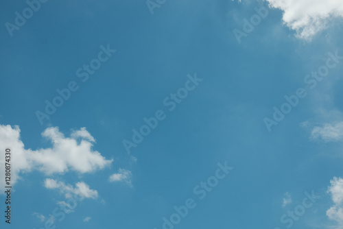 A simple, minimalistic scene of a lone white cloud floating in a vast blue sky, creating a clean and serene atmosphere
