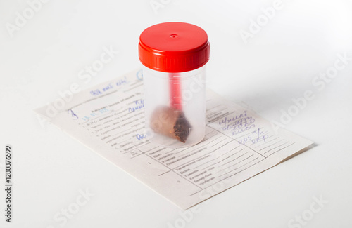 Sterile container with stool test and doctor's referral on white background, close-up photo