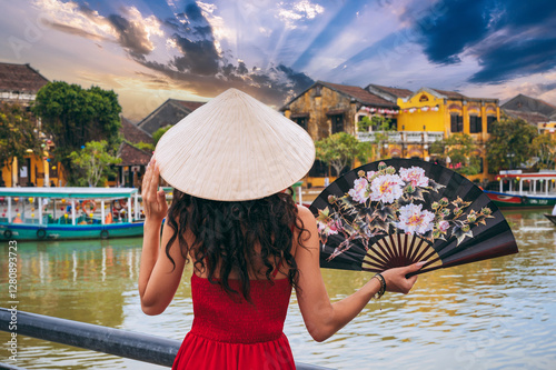 back of woman tourist traveler in a Vietnamese hat with a fan on a bridge in Hoi An in Vietnam in Asia photo