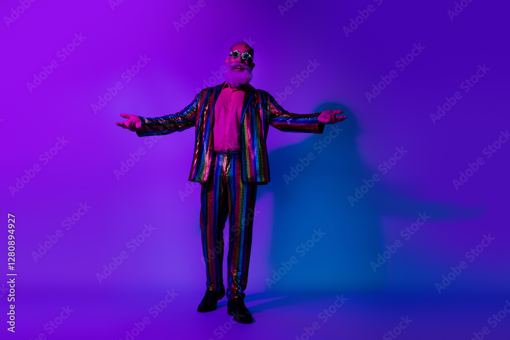 Full size photo of macho senior male perform showman dressed colorful sequins striped garment isolated on blue purple neon light background Full size photo of macho senior male perform showman dressed colorful sequins striped garment isolated on blue purple neon light background
